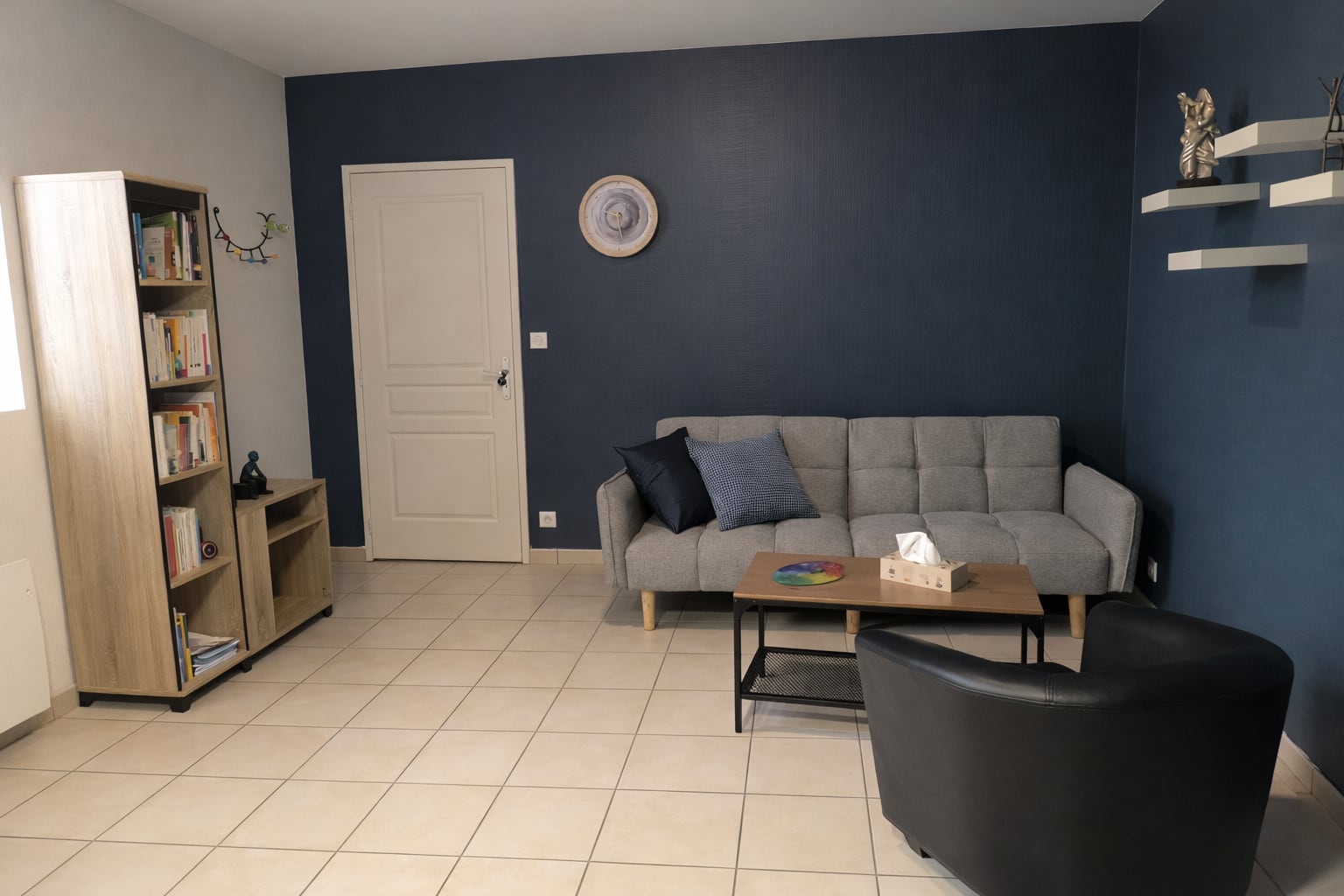Salle d'attente du cabinet de psychologie à Saint-Sornin — canapé, bibliothèque, ambiance calme